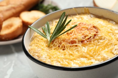 Photo of Tasty homemade french onion soup served in ceramic bowl, closeup