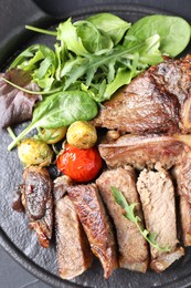 Delicious grilled beef meat, vegetables and greens on table, top view