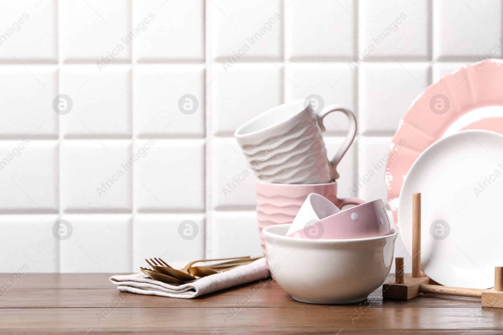 Photo of Beautiful ceramic dishware, cups and cutlery on wooden table, space for text