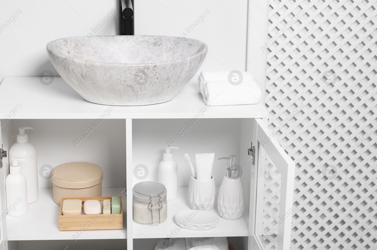 Photo of Different personal care products and bath accessories in bathroom vanity