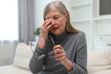 Overwhelmed woman with glasses suffering at home