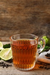 Photo of Glass cup of tasty bergamot tea on wooden table