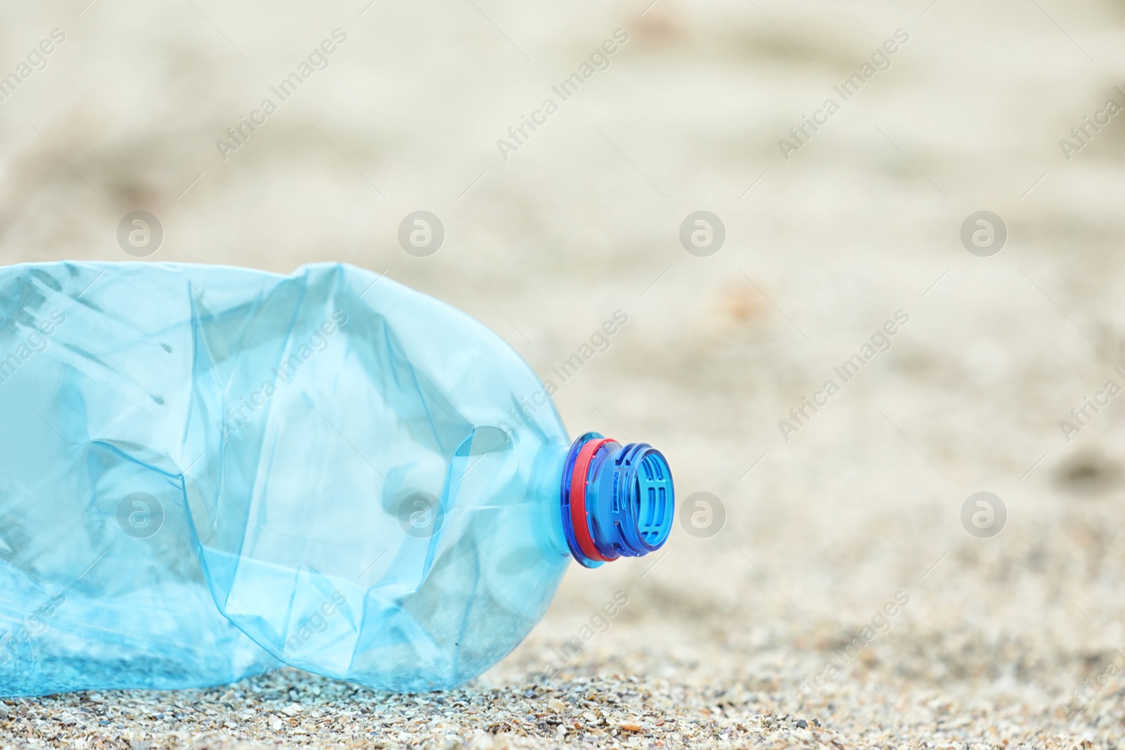 Photo of Used plastic bottle on beach, closeup with space for text. Recycling problem