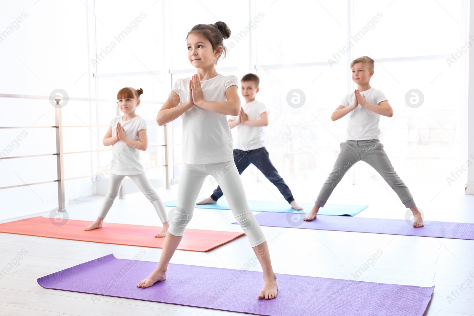 Photo of Little children practicing yoga in gym