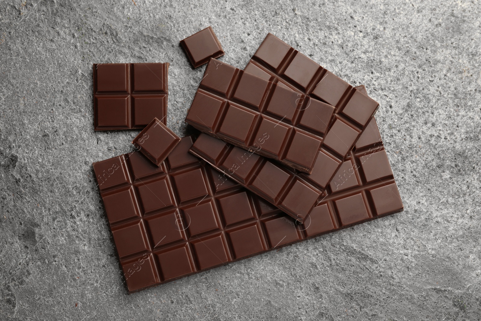 Photo of Delicious dark chocolate on grey table, flat lay