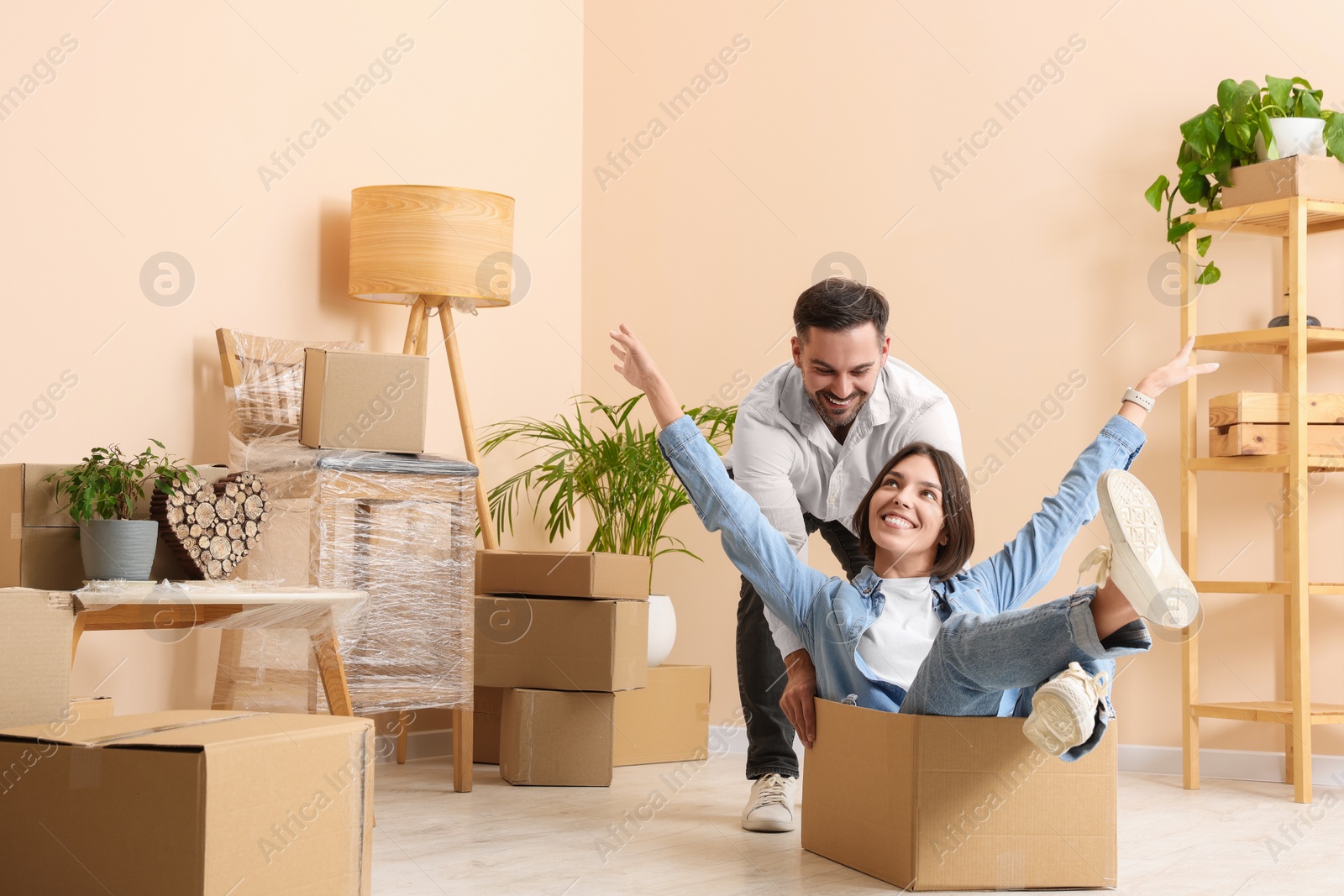 Photo of Happy couple having fun in new apartment. Moving day