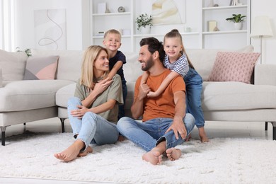 Photo of Happy family spending time together on soft carpet at home