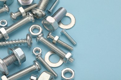 Photo of Many different fasteners on light blue background, closeup. Space for text