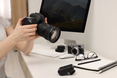 Photo of Photographer with camera at white table indoors, closeup