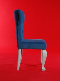 Stylish blue chair on red background. Element of interior design