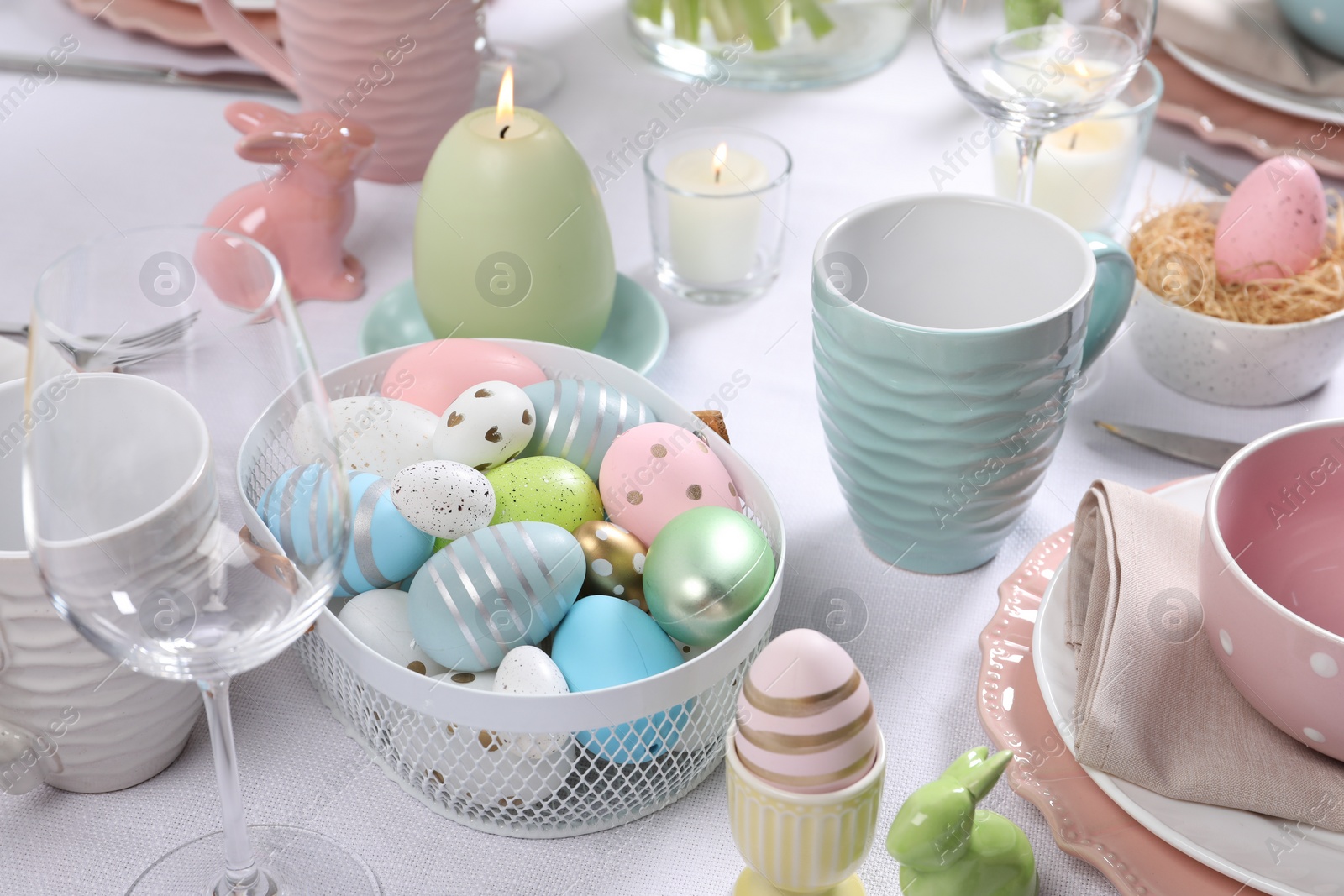 Photo of Festive table setting with painted eggs. Easter celebration