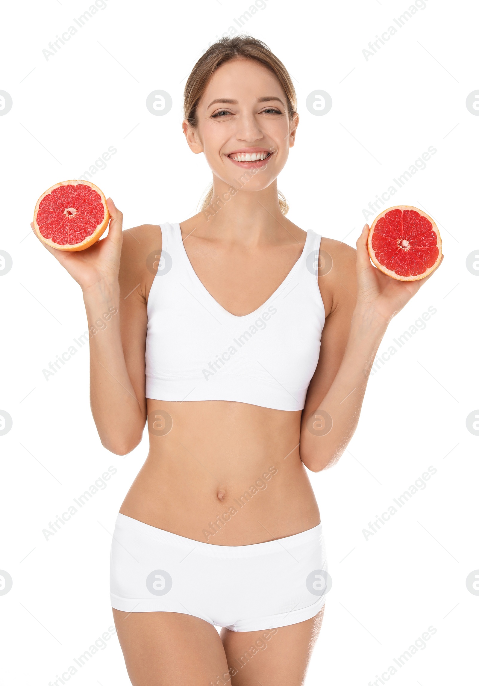 Photo of Happy slim woman in underwear holding grapefruit on white background. Weight loss diet