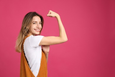 Photo of Strong woman as symbol of girl power on pink background, space for text. 8 March concept