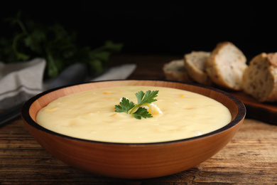 Photo of Delicious corn cream soup served on wooden table