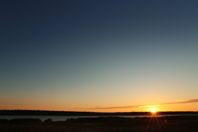 Photo of Picturesque view of beautiful sunrise on riverside. Morning sky