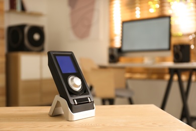 Photo of Remote control of audio speaker system on wooden table in room. Space for text