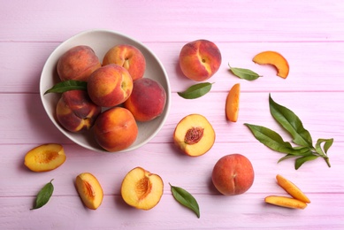 Photo of Fresh sweet peaches on pink wooden table, flat lay