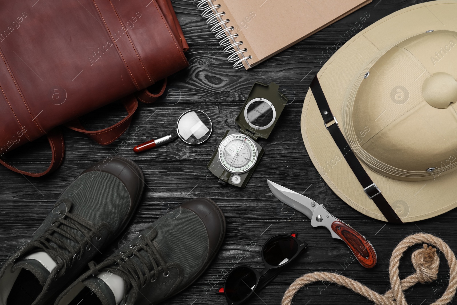 Photo of Flat lay composition with safari accessories on black wooden background