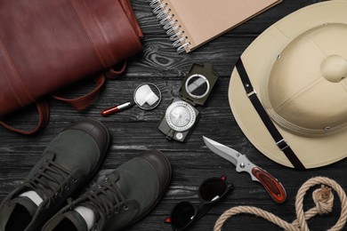 Photo of Flat lay composition with safari accessories on black wooden background