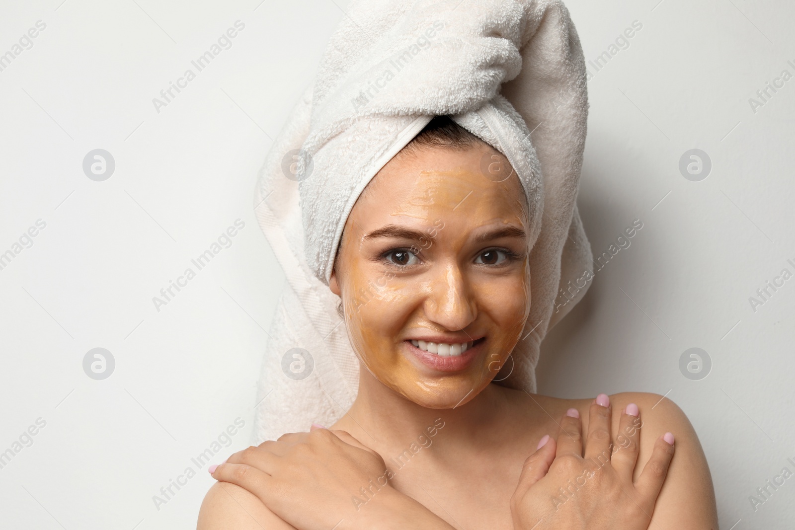 Photo of Beautiful woman with mask on face against light background