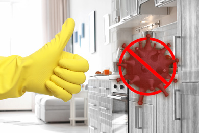 Keep your home virus-free. Woman showing thumb up in clean kitchen