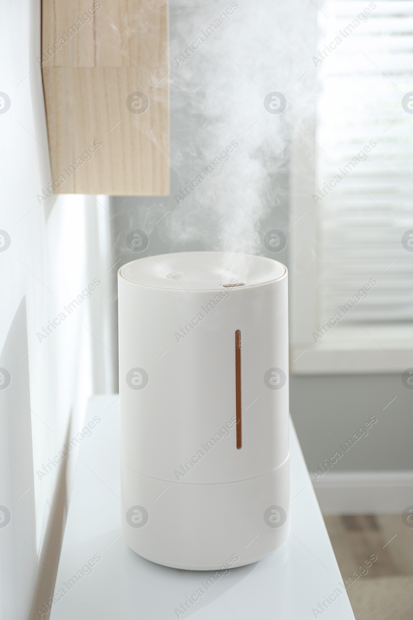 Photo of Modern air humidifier on table at home