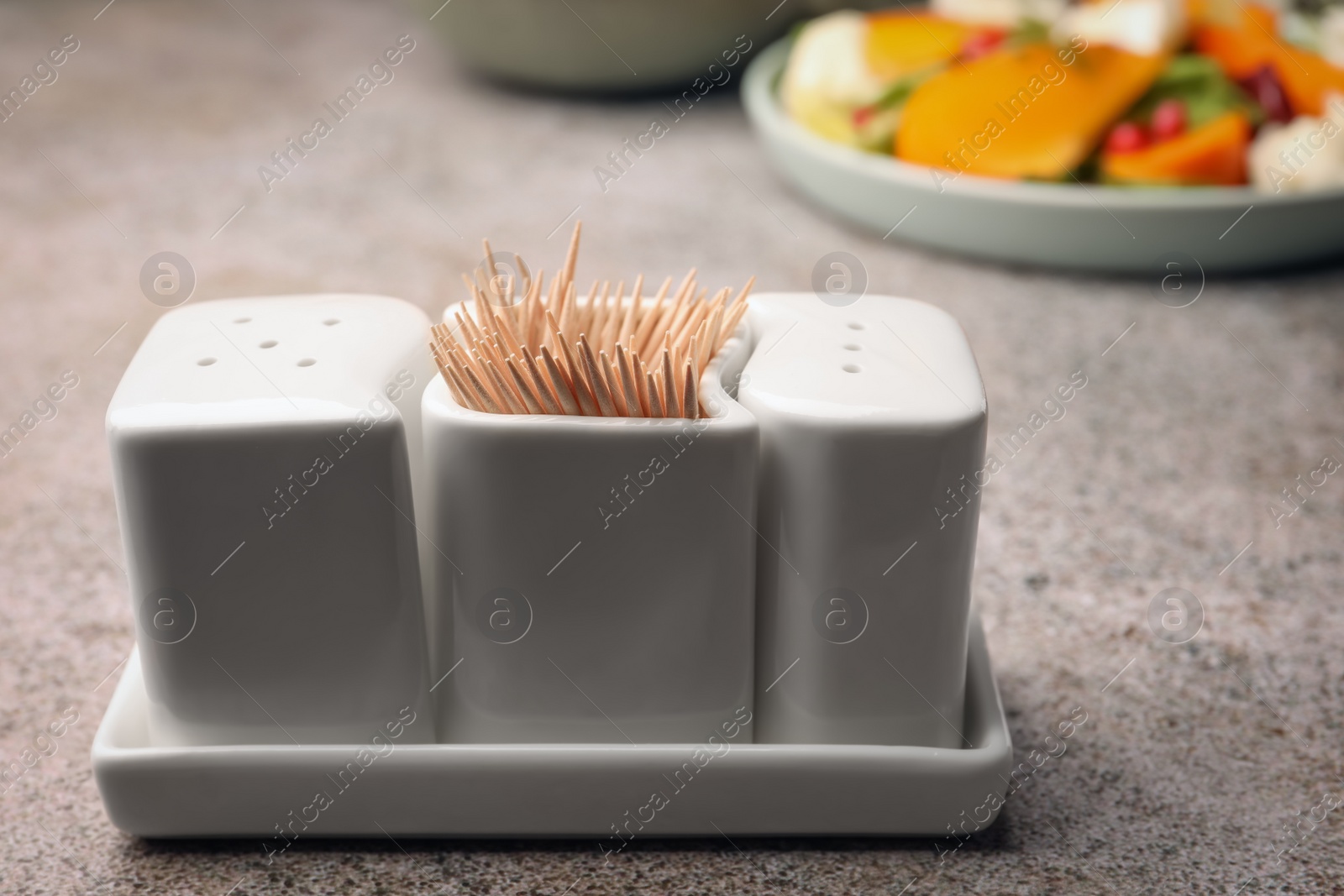 Photo of Holder with salt, pepper and toothpicks on grey table, closeup