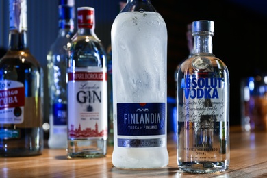 MYKOLAIV, UKRAINE - SEPTEMBER 24, 2019: Bottles of global vodka brands on wooden counter in bar