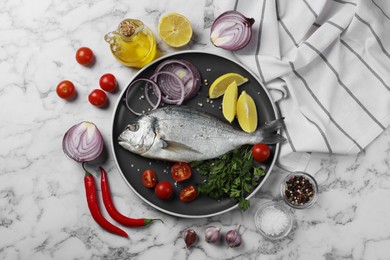 Photo of Fresh dorado fish and ingredients on white marble table, flat lay