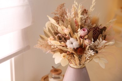 Photo of Bouquet of dry flowers and leaves indoors