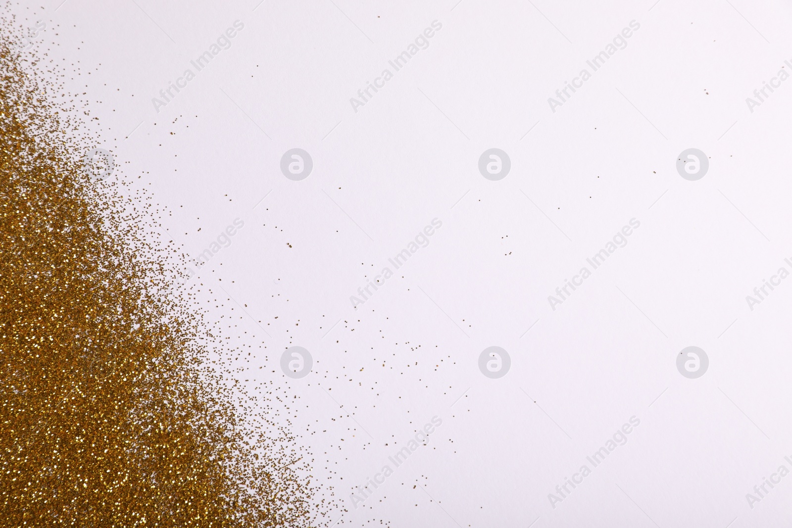 Photo of Shiny golden glitter on white background, top view