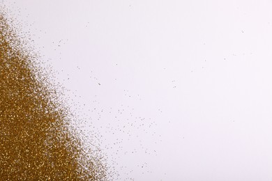 Photo of Shiny golden glitter on white background, top view