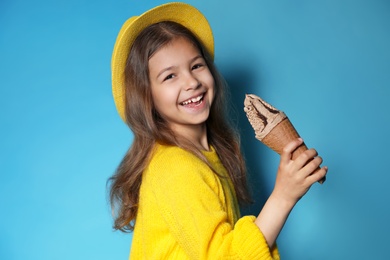 Photo of Adorable little girl with delicious ice cream against color background