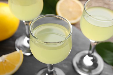 Photo of Tasty limoncello liqueur on table, closeup view