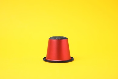 One plastic coffee capsule on yellow background