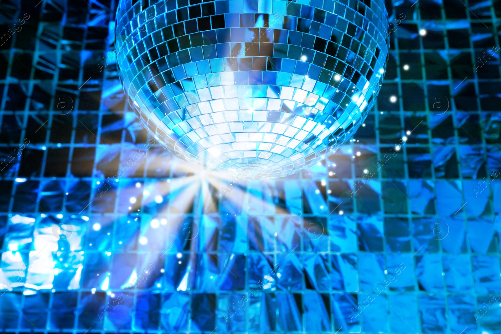 Image of Shiny disco ball against foil party curtain, low angle view. Bokeh effect