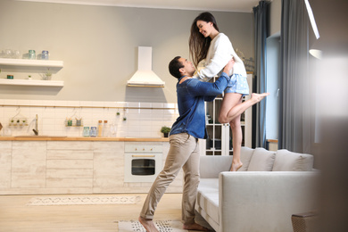 Photo of Lovely young interracial couple dancing at home. Space for text