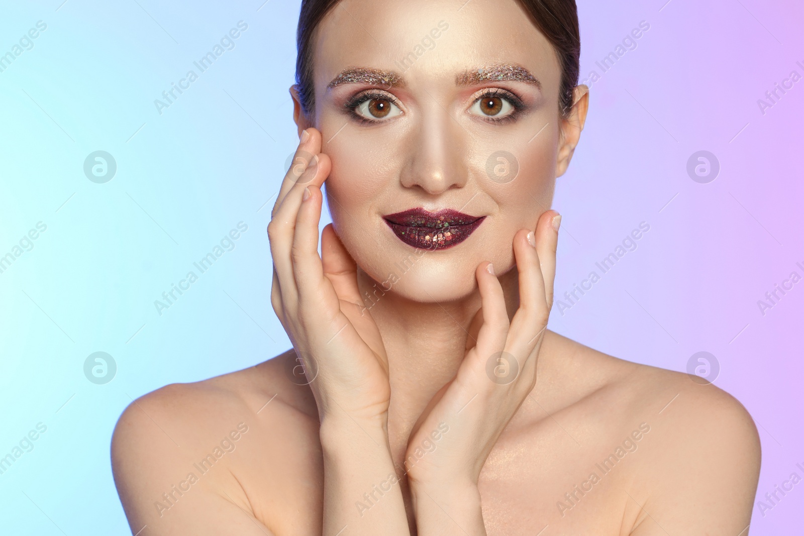 Photo of Beautiful young woman with glitter makeup on colorful background