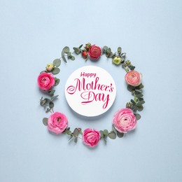 Image of Happy Mother's Day. Frame of beautiful ranunculus flowers and greeting card on light blue background, flat lay