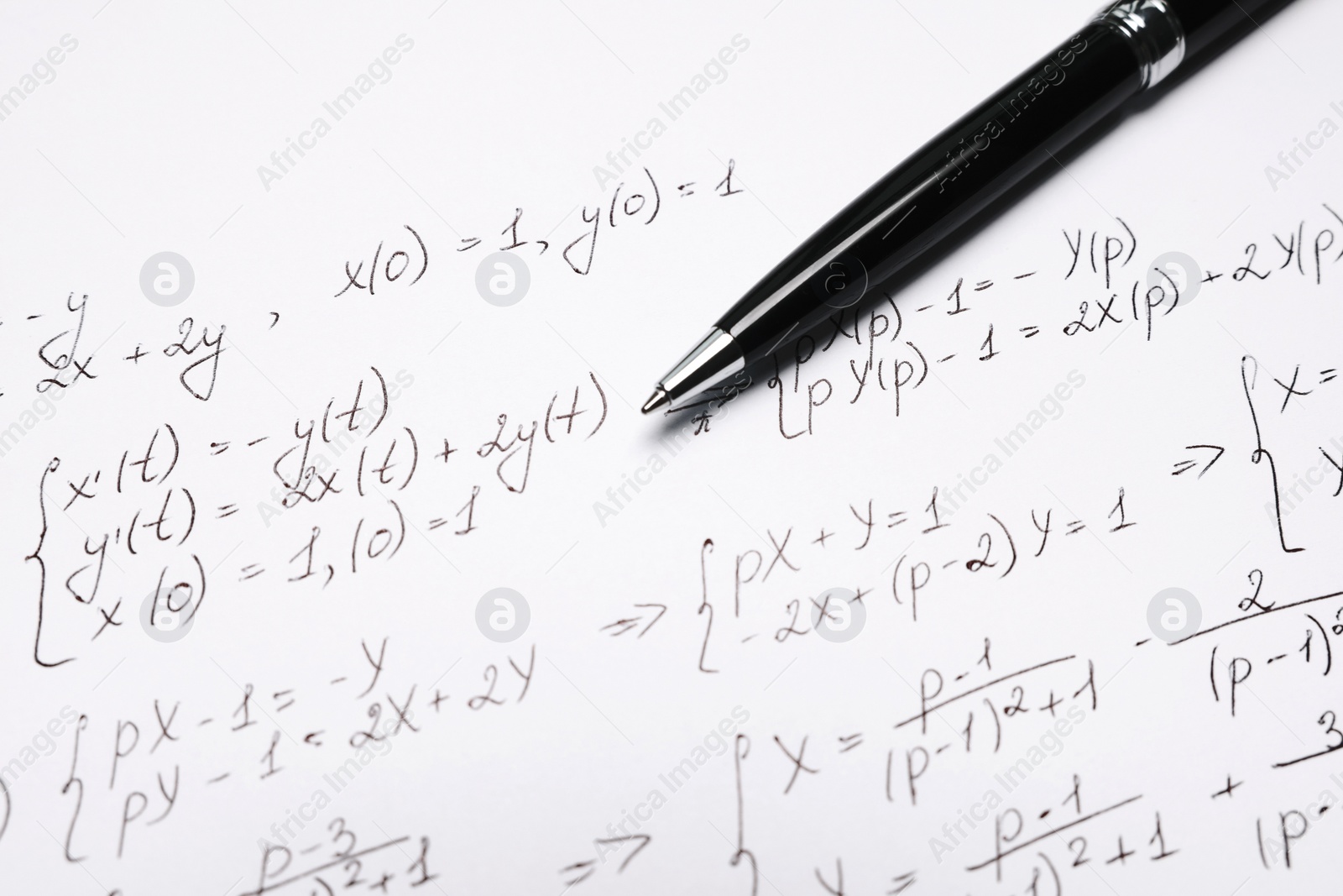 Photo of Sheet of paper with mathematical formulas and pen, closeup