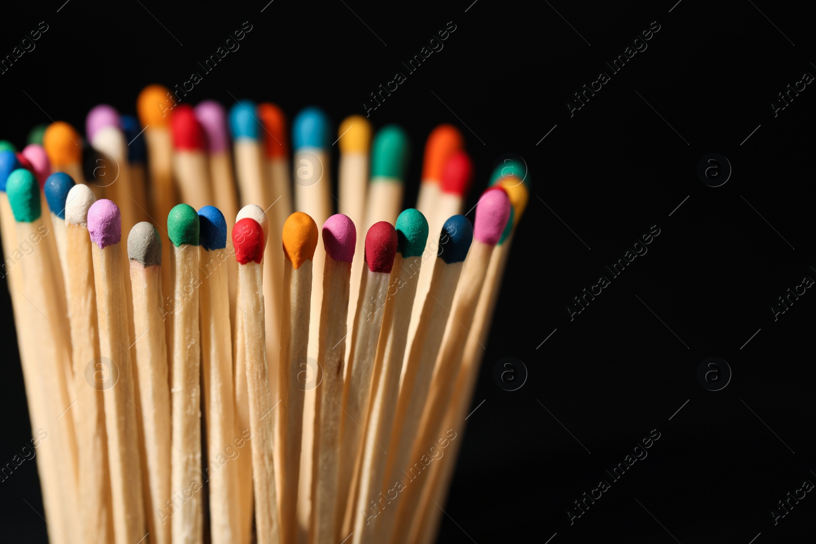 Photo of Matches with colorful heads on black background, closeup. Space for text