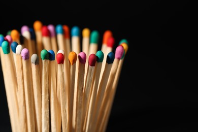 Photo of Matches with colorful heads on black background, closeup. Space for text