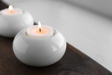 Photo of Beautiful burning wax candle in holder on table