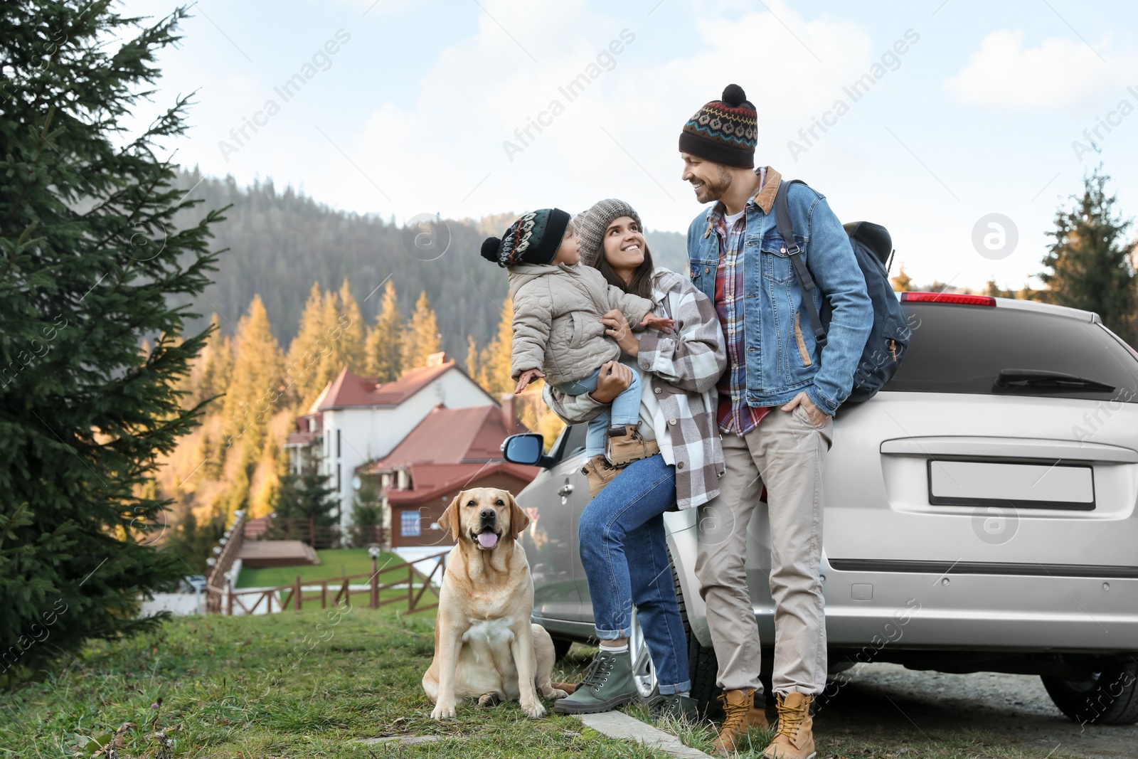 Photo of Parents, their daughter and dog near car in mountains, space for text. Family traveling with pet