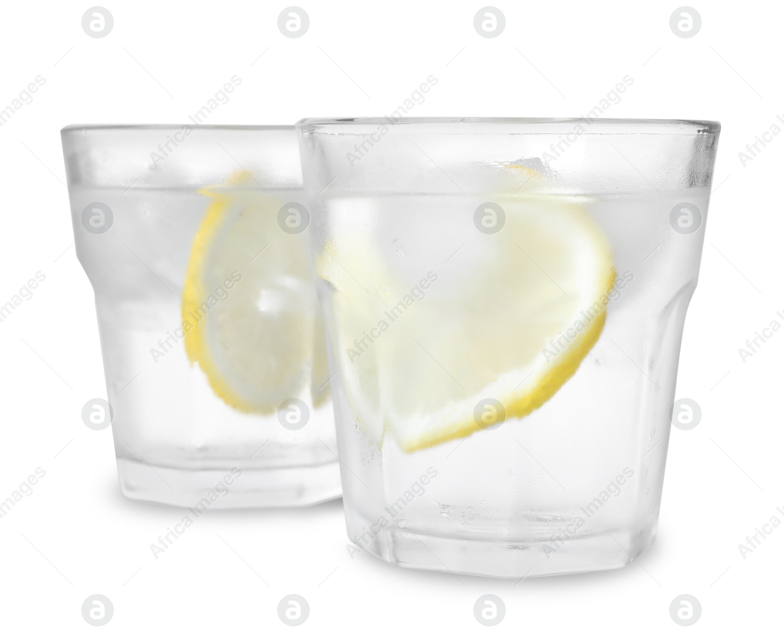 Photo of Glasses of vodka with ice and lemon isolated on white