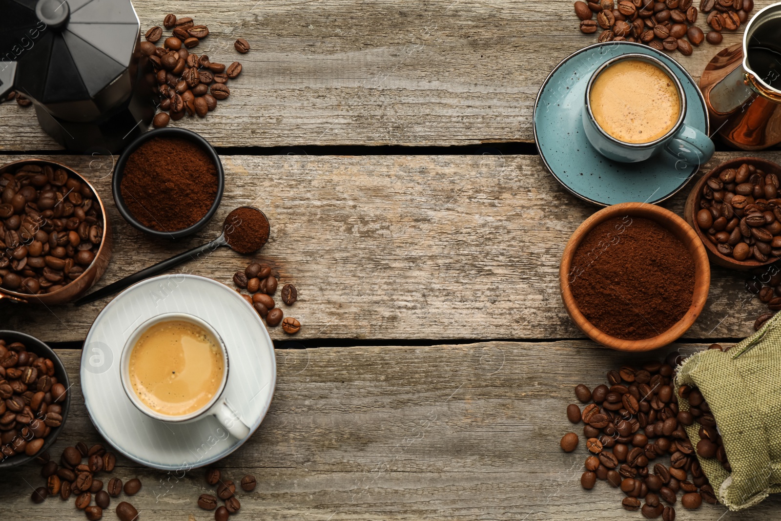 Photo of Coffee maker, beans, powder and cup of drink on wooden table, flat lay. Space for text