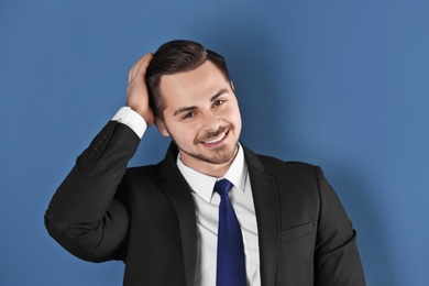 Portrait of young man with beautiful hair on color background