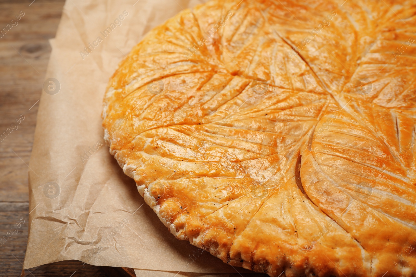 Photo of Traditional galette des rois on wooden table, closeup