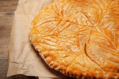 Traditional galette des rois on wooden table, closeup