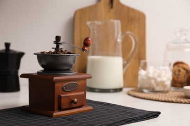 Photo of Vintage manual coffee grinder with beans on counter in kitchen
